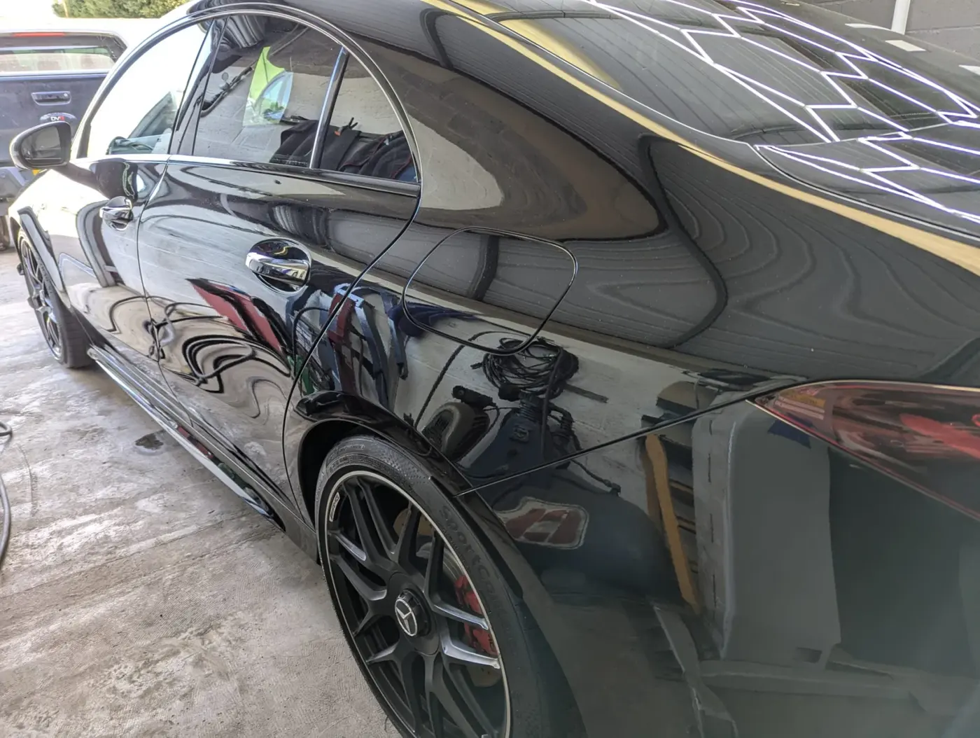 Machine polished black paintwork reflecting the hex lights in the WK Detailing studio